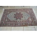 A Hand Knotted Woollen Rug with central medallion and red field - 234 cm x 142 cm - generally good