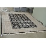 A hand knotted woollen rug with a black field and stylised border - generally good condition -