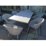 A Bramblecrest concrete and resin garden table and six chairs with cushions