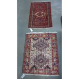 Two small hand knotted woollen rugs - 105 cm x 69 cm and 104 cm x 83 cm - both with minor wear -