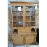 An Arts and Crafts oak bureau bookcase by Robson and Sons - Newcastle on Tyne - with a two door