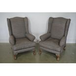 A pair of re-upholstered wing armchairs on carved ball and claw feet - 102 cm tall x 73 cm wide x