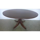 A mahogany oval breakfast table on four outswept legs