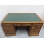 An early 20th Century Oak Twin Pedestal Nine Drawer Desk with a Leatherette inset top - 79 cm tall