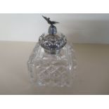 A large glass inkwell with silver embossed top surmounted by a bird - London 1900/01 - Maker JG&S -