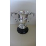 A silver twin handled trophy cup on stand - Chester 1913/14 - Maker HEB FEB - standing 19cm tall -