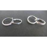 A pair of 18ct White Gold and Diamond Earrings - with a pair of unmarked white metal hoop earrings