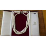A triple string of cultured pearls with a silver clasp - 47cm long and in good condition