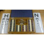 A boxed set of opticians lenses with two Snellens Charts and two Trial Frames