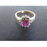 An 18ct ruby and diamond cluster ring size L - approx weight 3.8 grams - ruby approx 6mm x 4mm x 2.