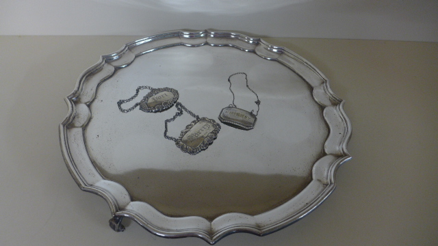 A late 19th Century/early 20th Century Georgian style silver plated waiter of raised on three feet,