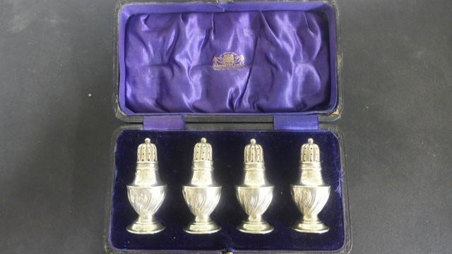 A boxed set of four silver peppers - Chester 1910/11 - approximate total weight 1.