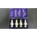 A boxed set of four silver peppers - Chester 1910/11 - approximate total weight 1.