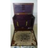 An Edwardian oak stationary cabinet with fall front, subdivisions,