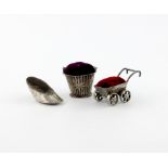 A small collection of three silver pin cushions, two with later cushions, modelled as a pram, a