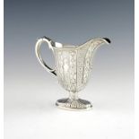 A Victorian silver cream jug, by George Ivory, London 1854, oval tapering form, with panels of