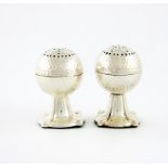 A pair of novelty silver pepper pots, by W. Aitken, Birmingham 1915, modelled as golf balls, pull-