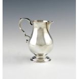 A George II silver 'sparrow-beak' cream jug, maker's mark worn, London 1733, baluster form, scroll