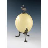 An electroplated mounted emu egg, mounted with a standing emu, on three leaf capped claw feet,