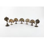 A set of five metalware menu card holders, unmarked, possibly Indian, modelled as standing peacocks,