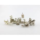 A small collection of silver miniatures, comprising figural groups: a windmill, canal and carriage