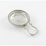 A George III silver lemon strainer, marks worn, possibly London 1774, circular form, pierced body,