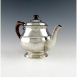 A silver tea pot, by Suckling Limited, Birmingham 1933, circular form, scroll handle, domed cover