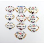 A collection of ten enamel wine labels, cartouche and escutcheon form, with black lettering on a