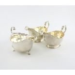 A pair of silver sauce boats, by Mappin and Webb, Birmingham 1928/29, panelled oval form, scroll