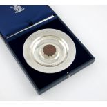 By C.N. Lawrence, a modern silver dish with a cartwheel penny, London 1997, number 24/200,