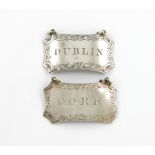 A pair of wine labels, unmarked, shaped rectangular form, canted corners, engraved foliate scroll