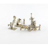 A small collection of four miniature silver figural groups, comprising: a man cutting a pig carcass,
