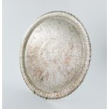 A metalware tray, circular form, shaped border, chased foliate and scroll decoration, diameter 36.