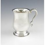 A silver mug, by The Barker Brothers, Birmingham 1932, baluster form, leaf capped scroll handle,