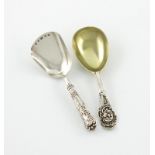 A Victorian silver-gilt caddy spoon, by Henry Holland, London 1869, the terminal with a mask, plus a