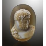 A carved agate cameo, circa 1800. Depicting Hercules in profile with short curled hair and beard,