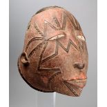 A Makonde helmet mask Mozambique wood with raised scarifications and the top with a shaped panel