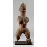 A Dogon female figure Mali wood, with incised geometric decoration and with an encrusted patina,