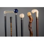 λ Six walking canes including one with an ivory ball handle initialled H.H, with a silver collar,