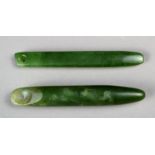 Two Maori ear pendants New Zealand greenstone; one cylindrical with a tapering end, the other