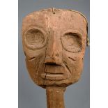 A Chancay mask Peru wood with hollow eyes and hooked nose, with a pointed stem, 33cm high.