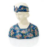 An unusual Longwy pottery bust of a woman, modelled with downcast look, wearing floral headband