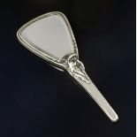 An Art Nouveau white metal hand mirror, triangular mirror with tapering handle, cast in relief