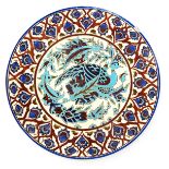 An Iznik style wall charger probably by Boch Freres Keramis, enamelled to the well with a stylised