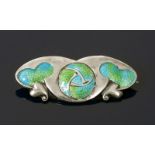 An Art Nouveau silver and enamel bar brooch, cast in low relief with heart-shaped foliage and