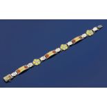 A James Fenton silver and enamel bracelet, cast with alternate flower and geometric panels,