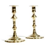 A pair of George III brass candlesticks, each with a lobed socket, a knopped stem and a petal