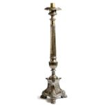 An 18th century Italian silvered brass altar candlestick, the urn shaped top above a fluted and