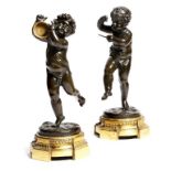 A pair of 19th century French bronze cherub musicians in the manner of Clodion, one holding a