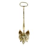 Hunting interest. A brass fox's head doorstop, with a ring handle and a turned stem, above a lead